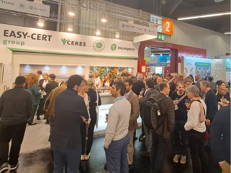 Menschen beim Apero vor dem Messestand Biofach